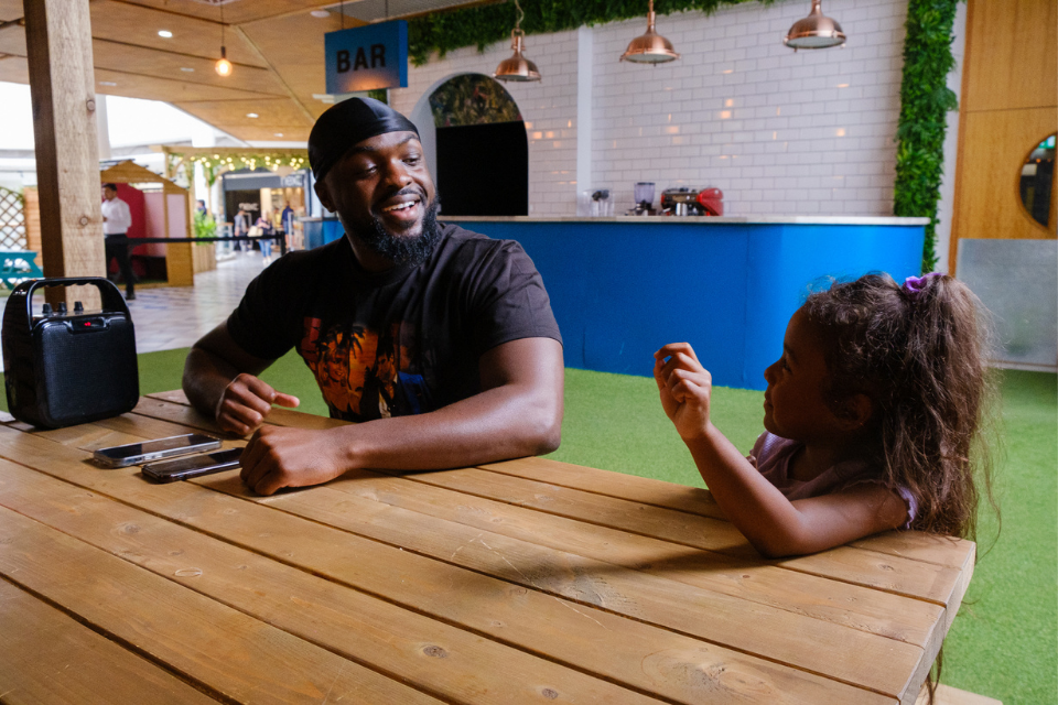 An young male rapper having a pleasant conversation with a small female child