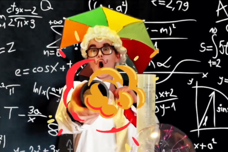 A person in a blonde curly wig and umbrella over their head stood in front of a blackboard containing various mathematical equations