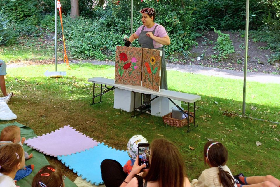 Actress Shaunna Duffy performing behind a large book that is showing flowers to the audience