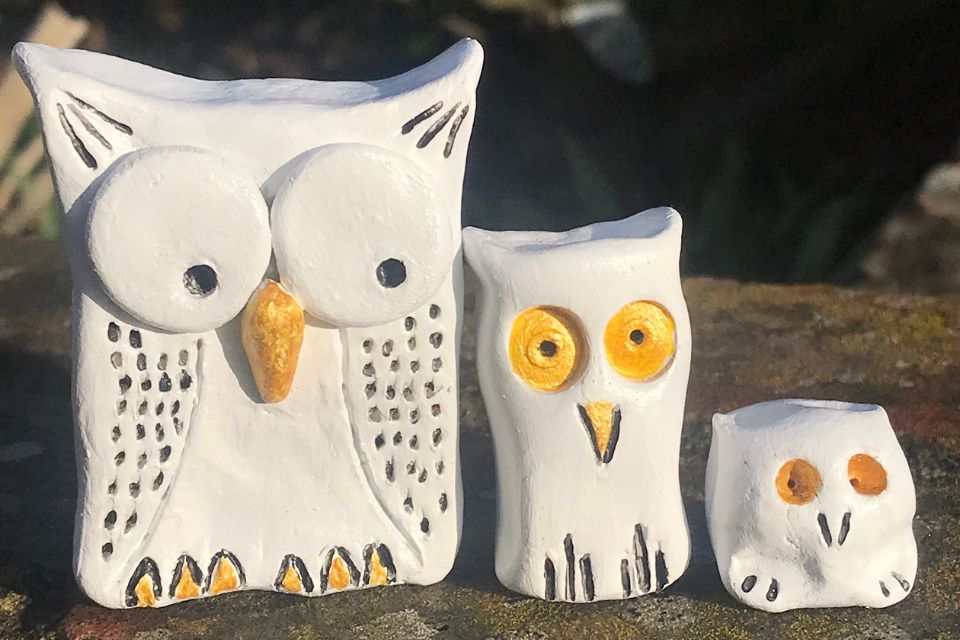 Three clay owl figurines with white and yellow colouring