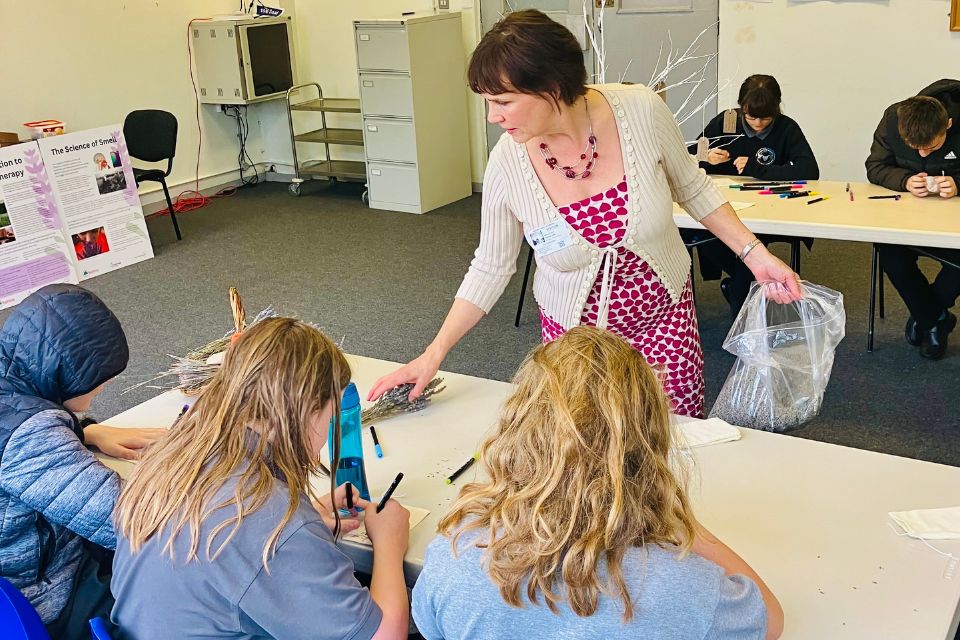 Melanie Dean providing lavender to two tables of school children