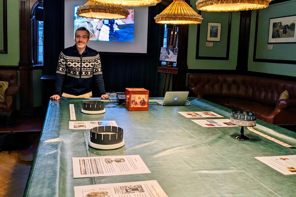 A man stood at the end of a pool table with zoetrope equipment laid out