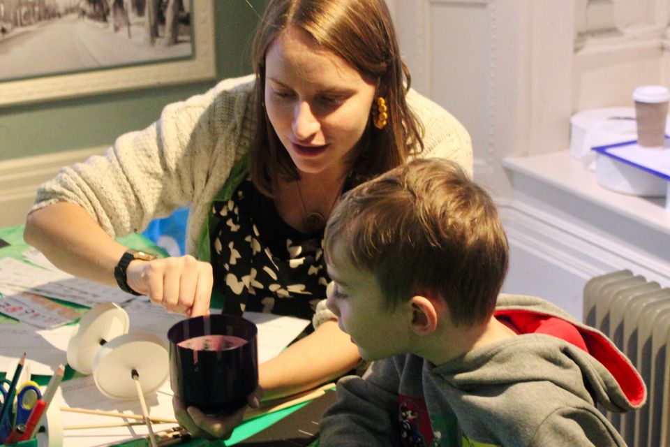 A woman sampling a zoetrope to a small boy