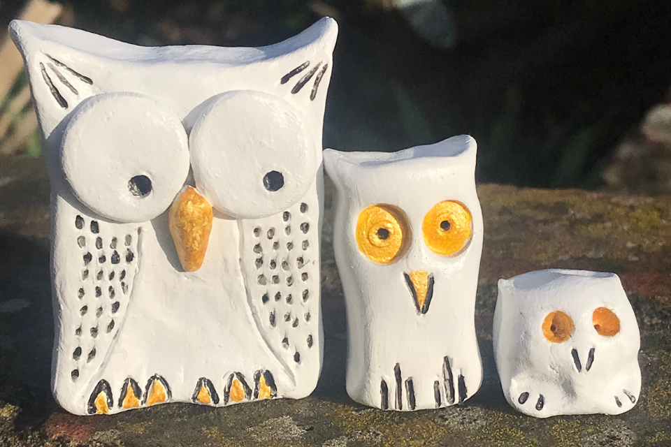 Three white clay cubes and cuboids modeled into the shape of owls