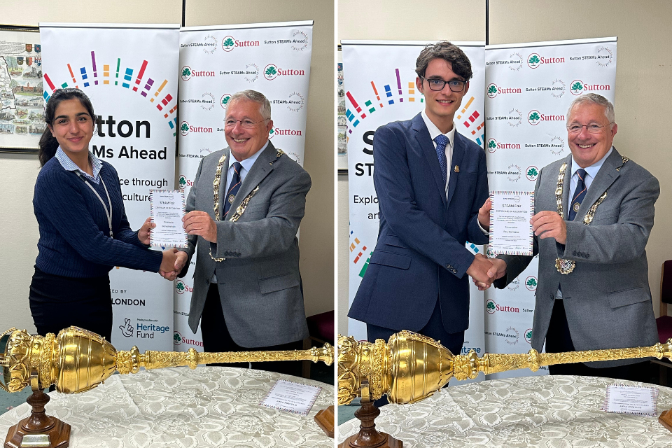 Two students shaking hands with Mayor Cllr Colin Stears stood behind a golden scepter