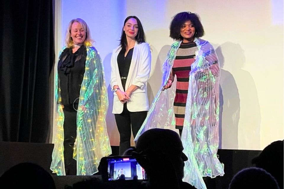Three women stood on stage