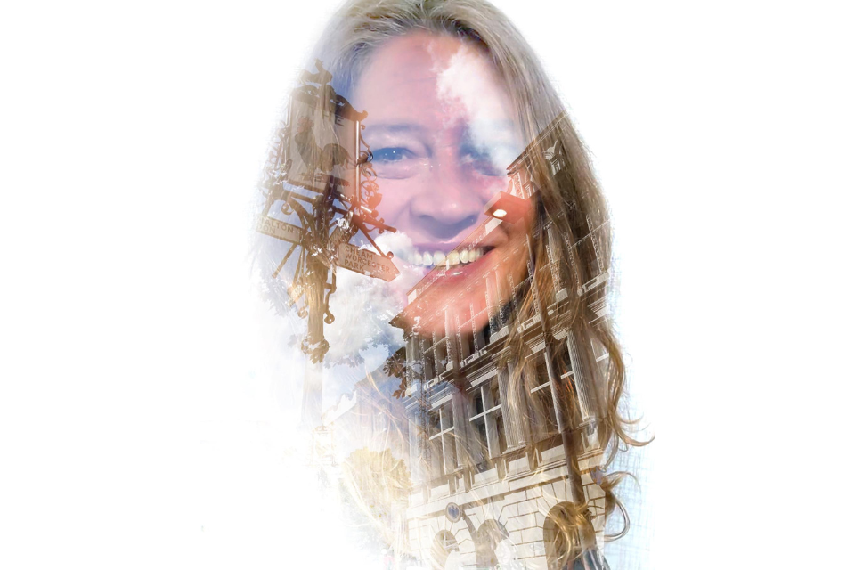 A translucent image of a blonde woman with a building super imposed on her face and hair