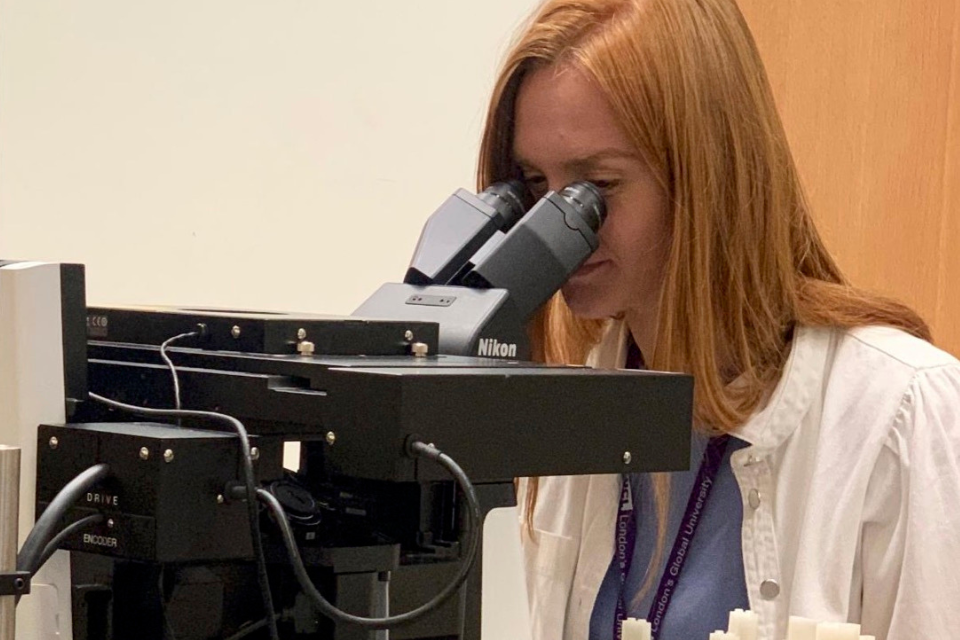 A woman looking into a microscope